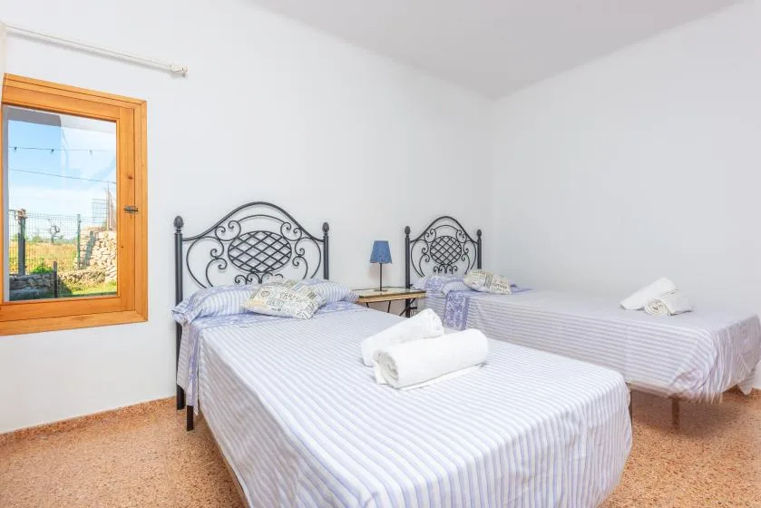 A bedroom with two beds and a window.