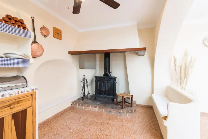 A living room with a black stove beneath a wooden mantel.