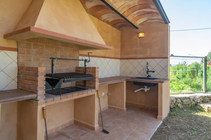 An outdoor cooking area with a built-in grill and sink.