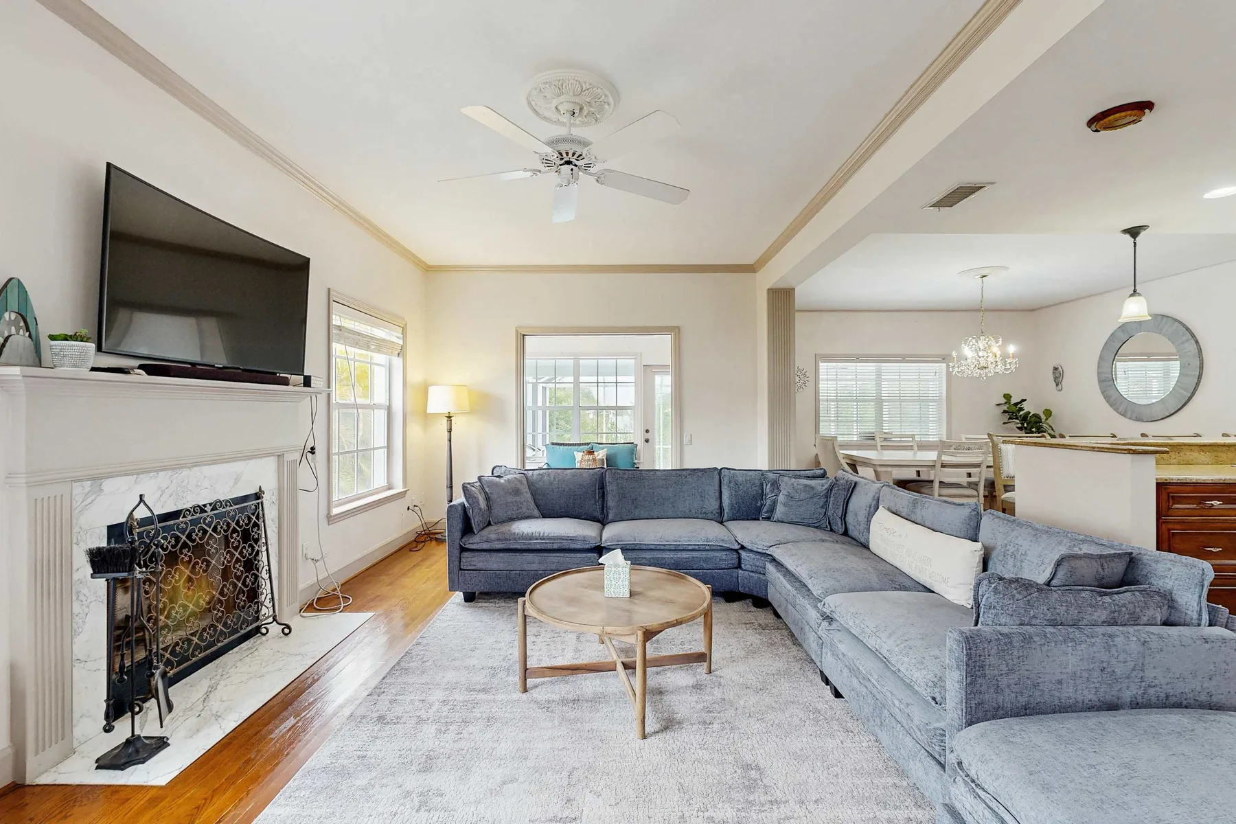 A living room with a large sectional seating area and fireplace.