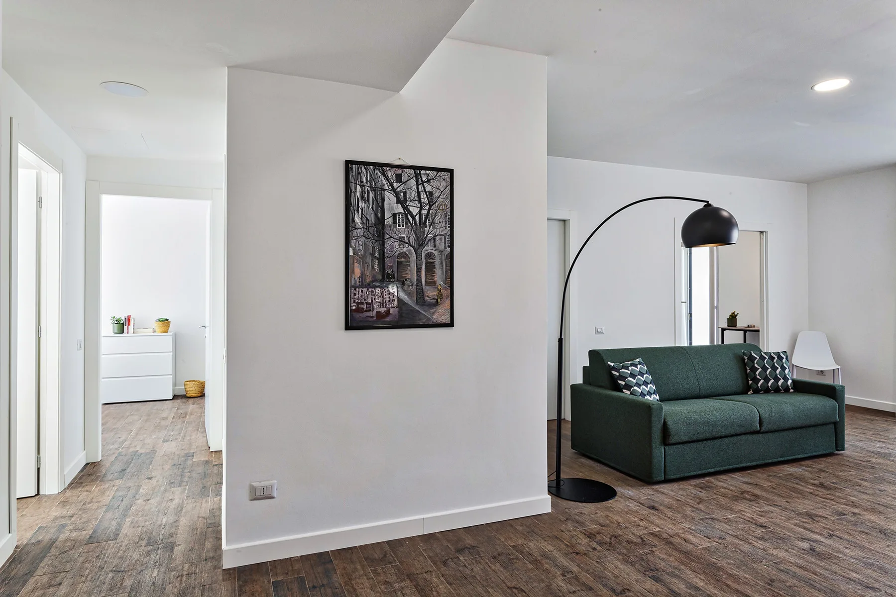Una sala luminosa con asientos verdes y una gran lámpara de arco.