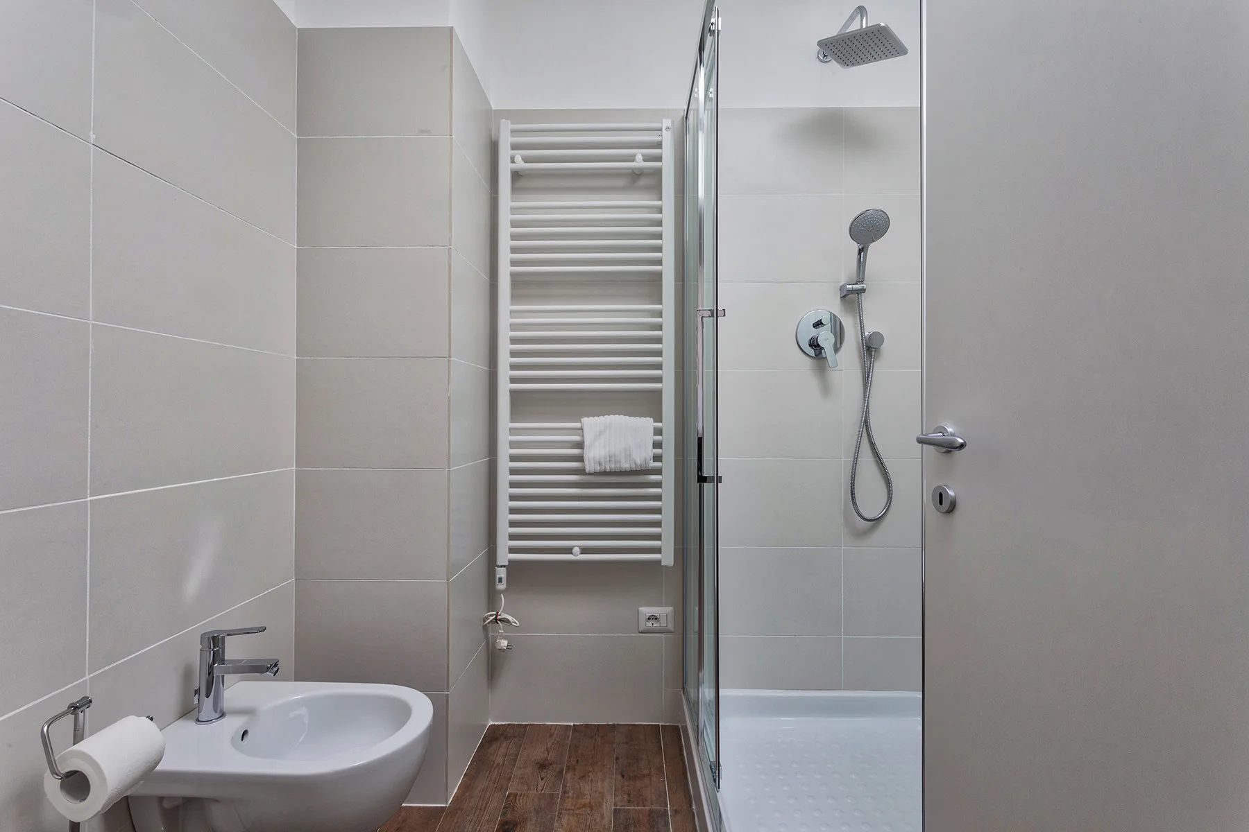 Un baño alicatado con lavabo, toallero calefactable y ducha.