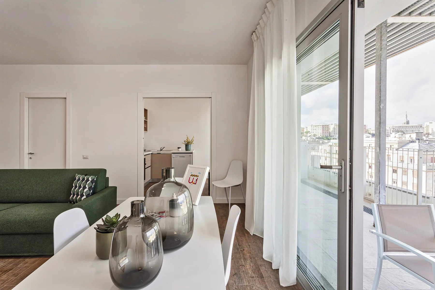 Un comedor luminoso con una mesa junto a grandes ventanales que dan a un balcón.