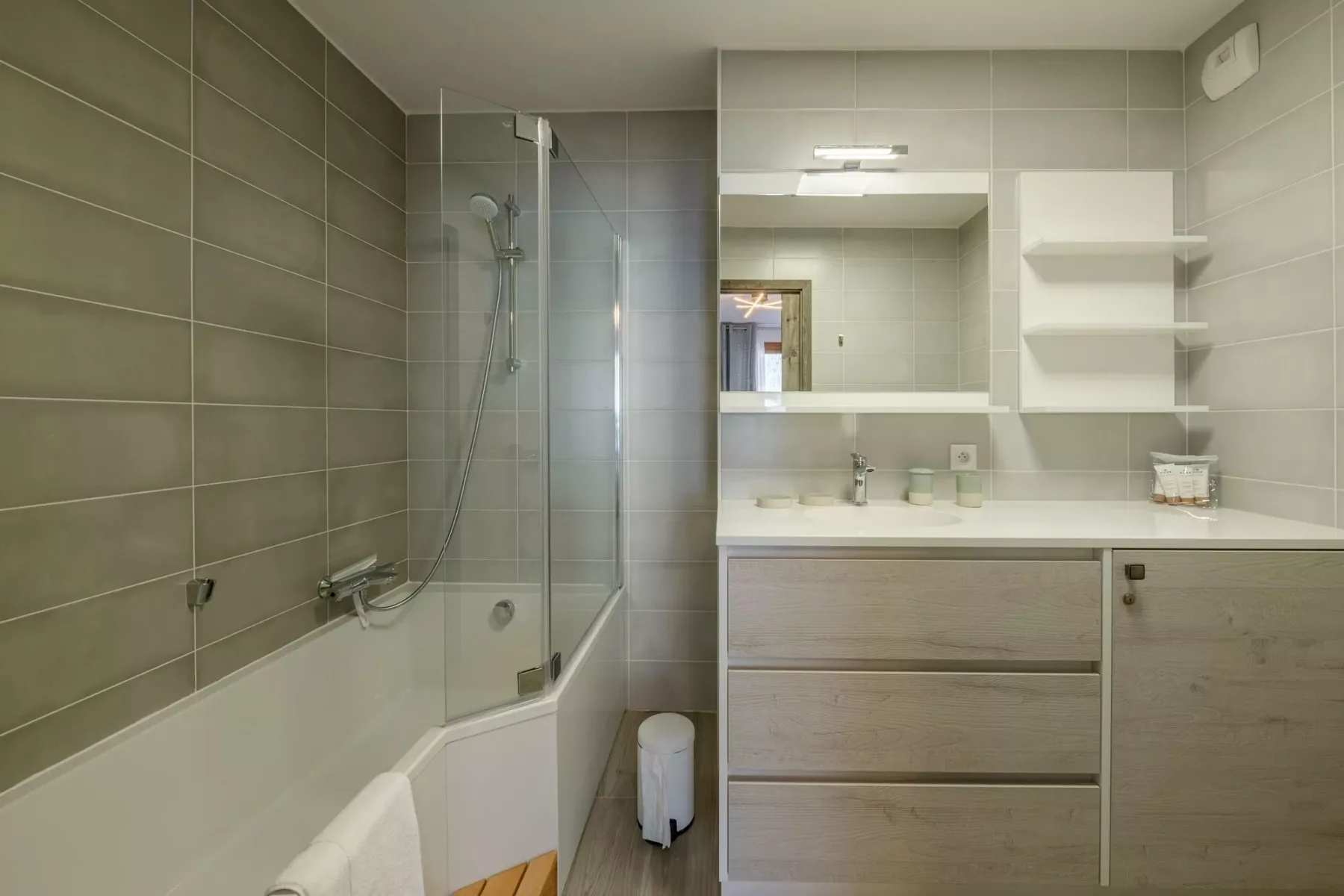 A tiled bathroom with a bathtub, shower, and wide vanity.