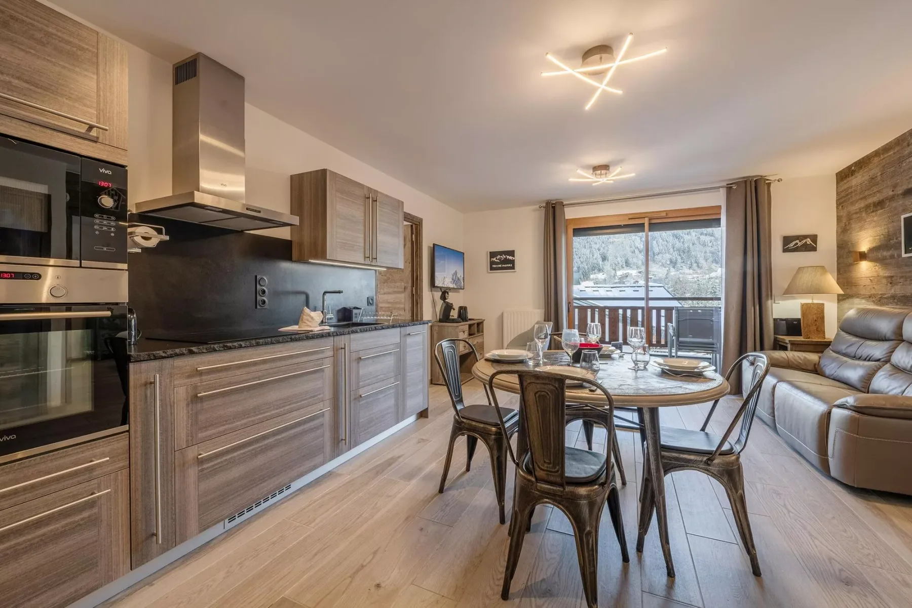 An open-plan kitchen and dining area with seating beside a window.