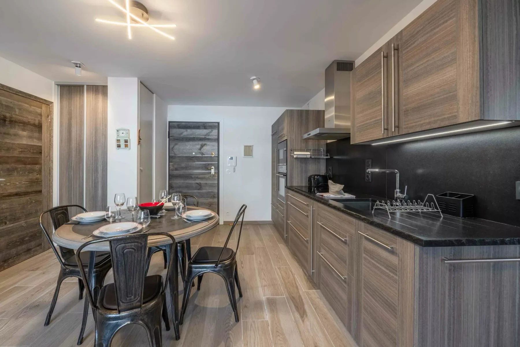 An open-plan kitchen and dining area with wood cabinetry and a set table.