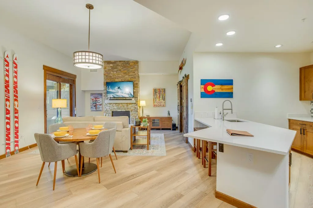 Sala de estar y cocina de concepto abierto, con mesa de comedor e isla central.