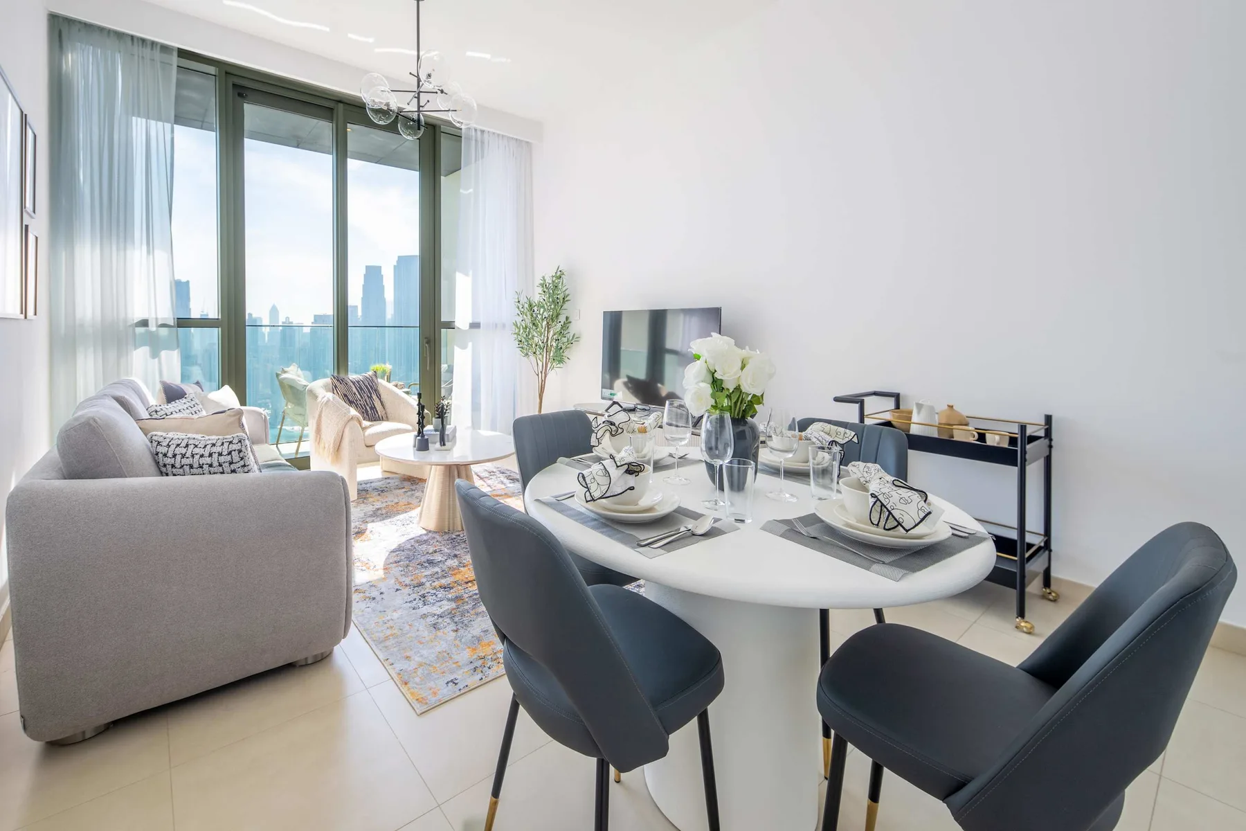 A bright living and dining area with seating beside large windows.