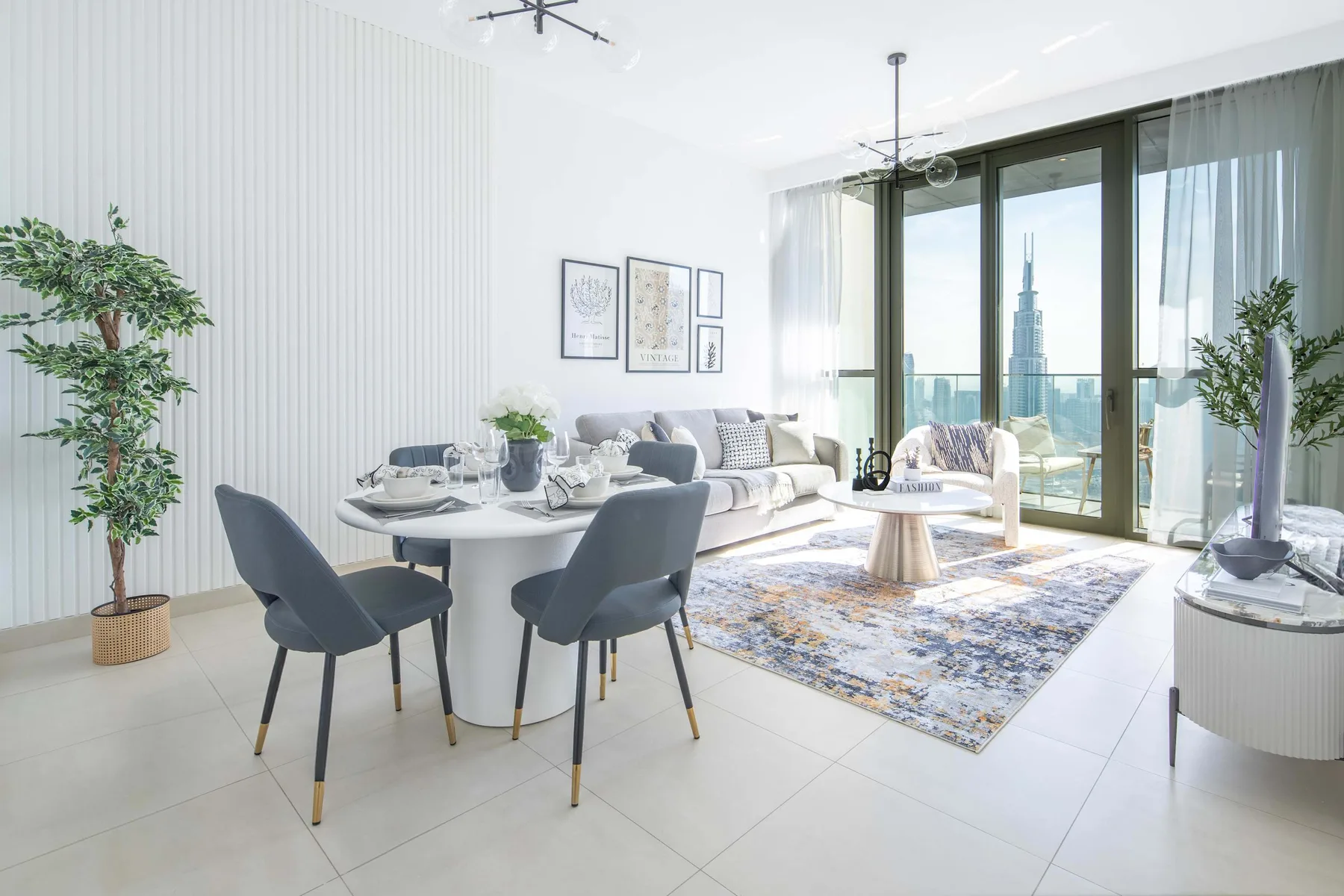 A bright living and dining area with a round table and seating beside large windows.