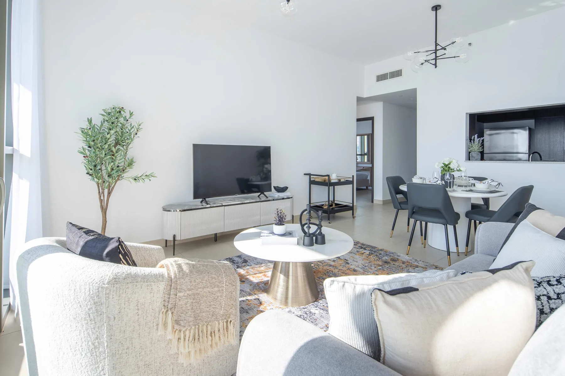 A bright living and dining area with seating around a low table.
