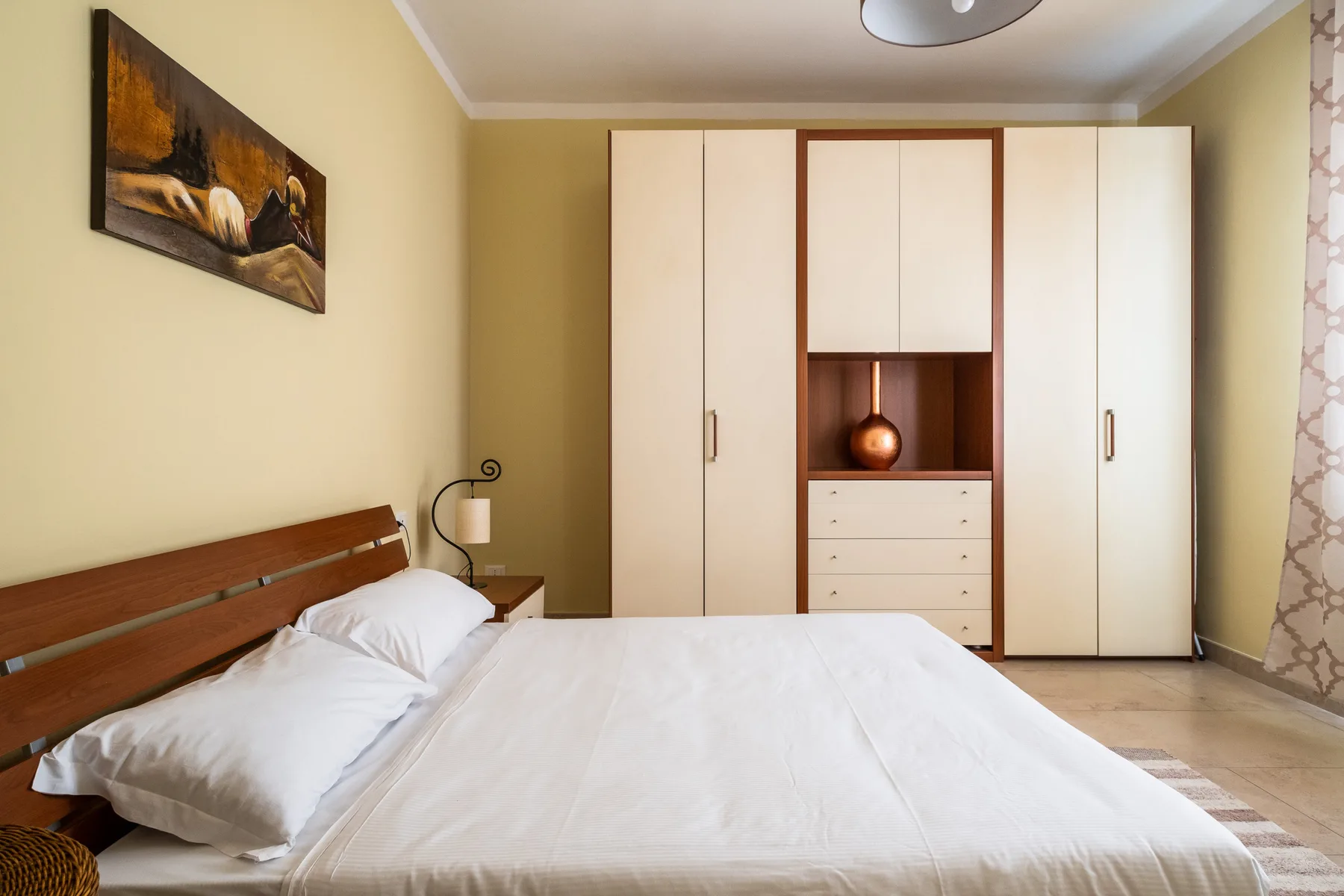 Un dormitorio con una cama bien hecha y un armario grande.