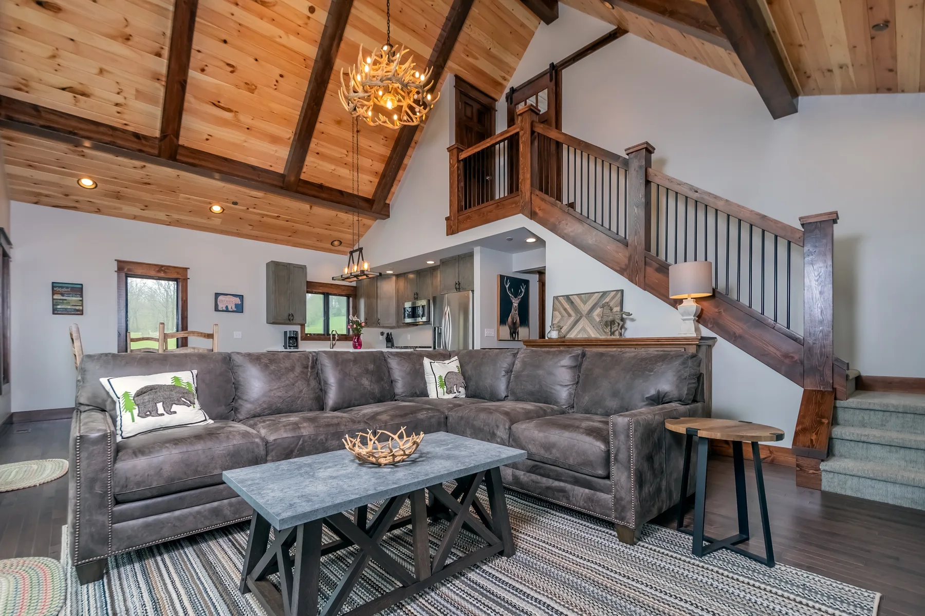 Sala de estar con un amplio espacio de asientos bajo un techo con vigas de madera.