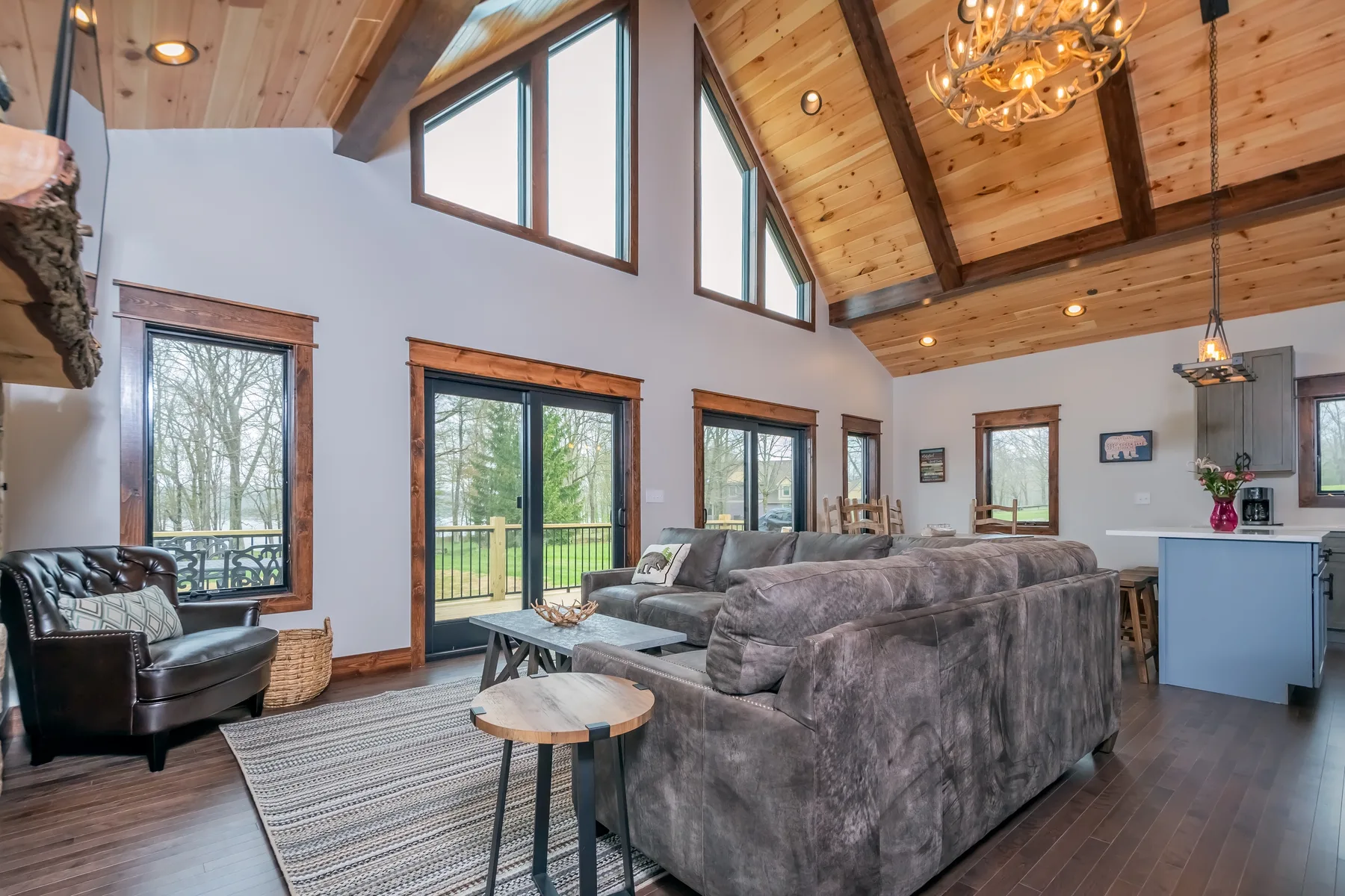 A spacious living room with seating beneath a high wooden ceiling.