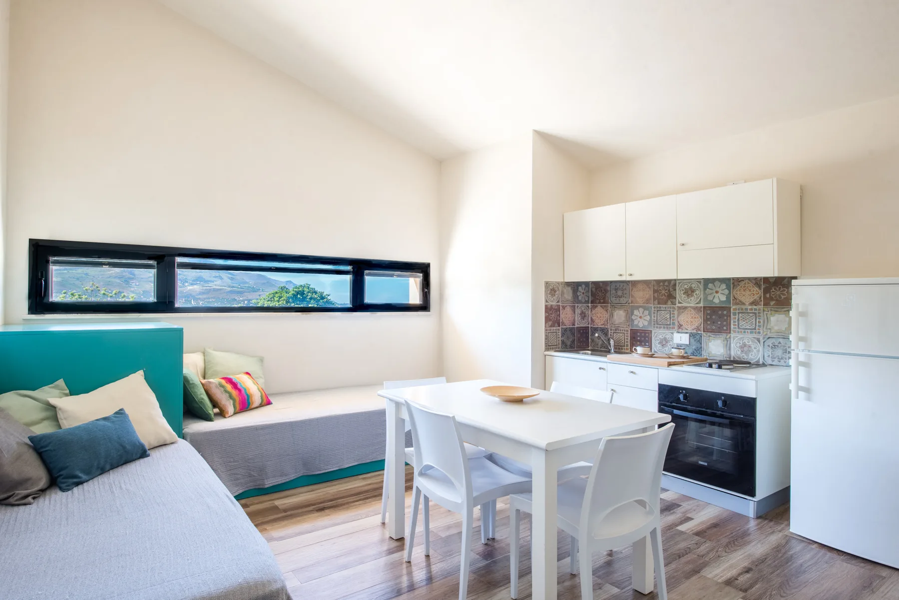 A bright kitchen and dining area with a table beside built-in seating.