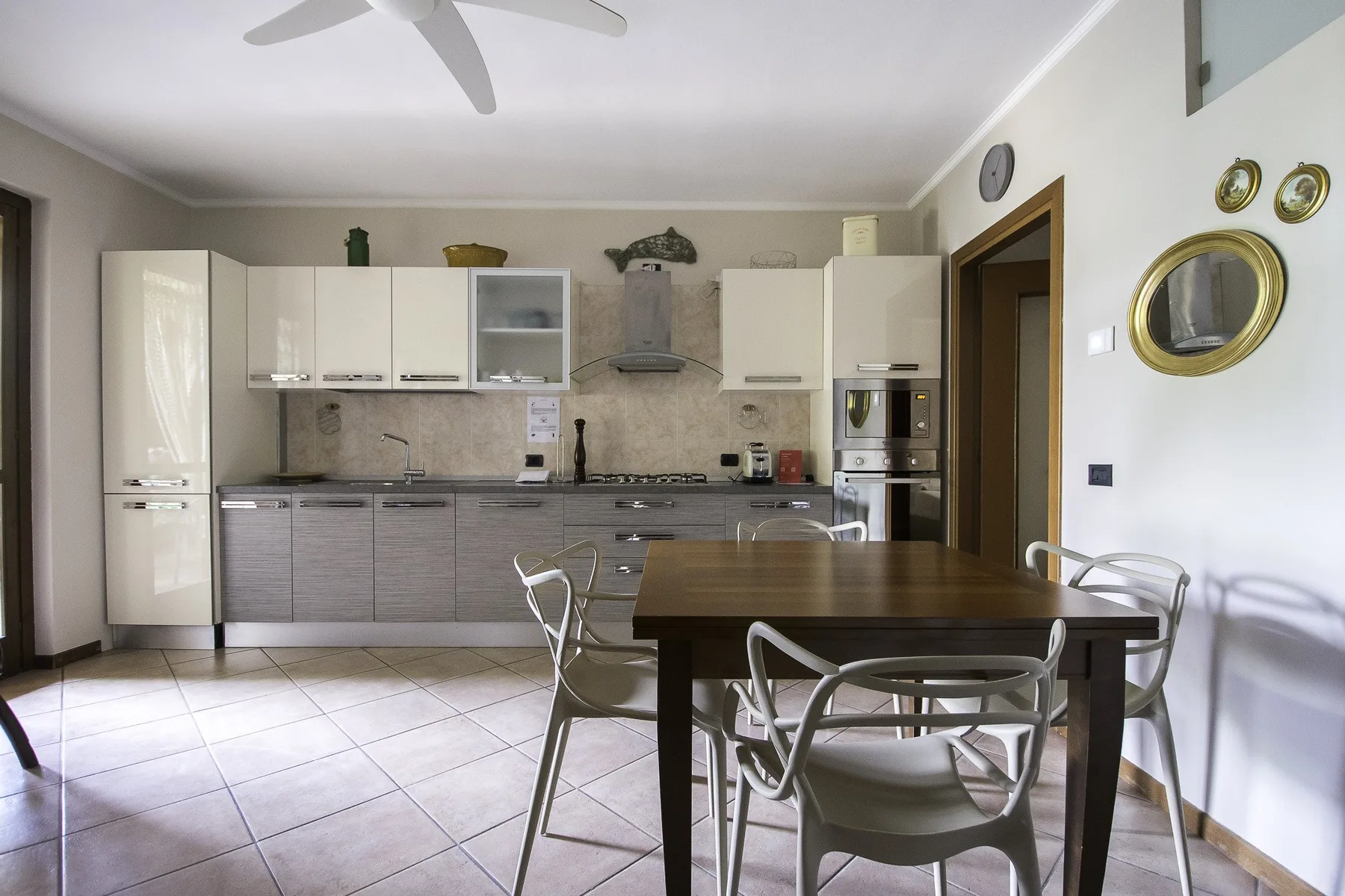 A kitchen and dining area with cabinets, appliances, and a table surrounded by seating.