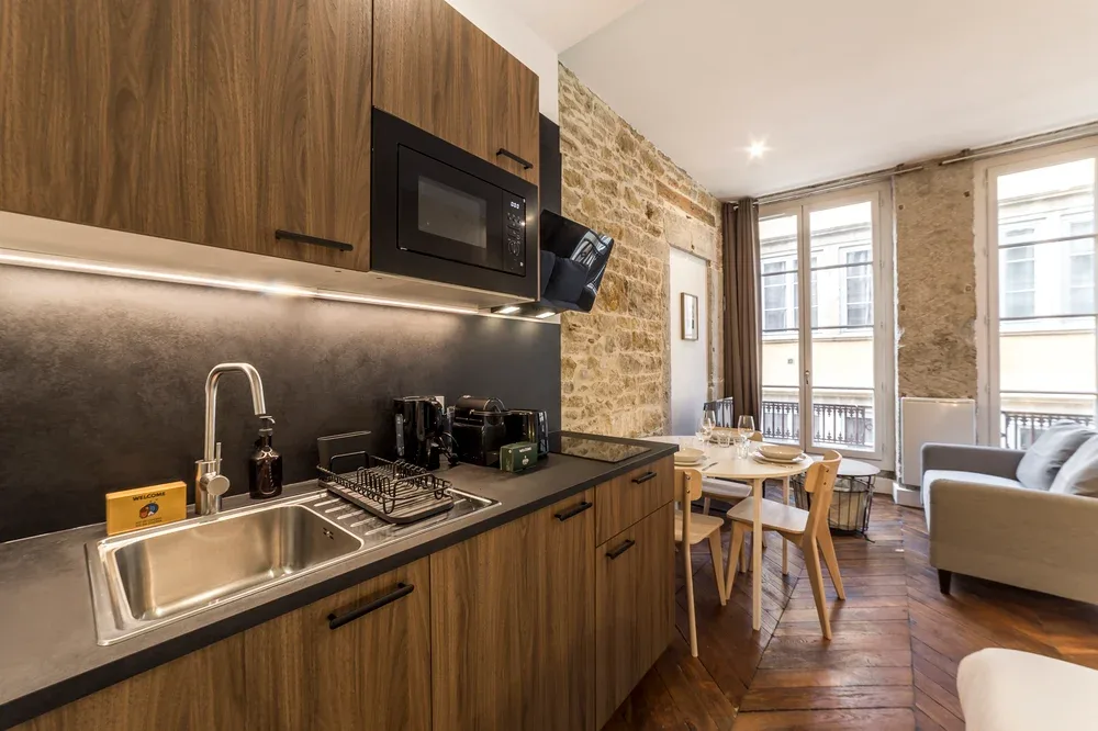 Cocina y comedor con muebles de madera, una encimera y una mesa de comedor.