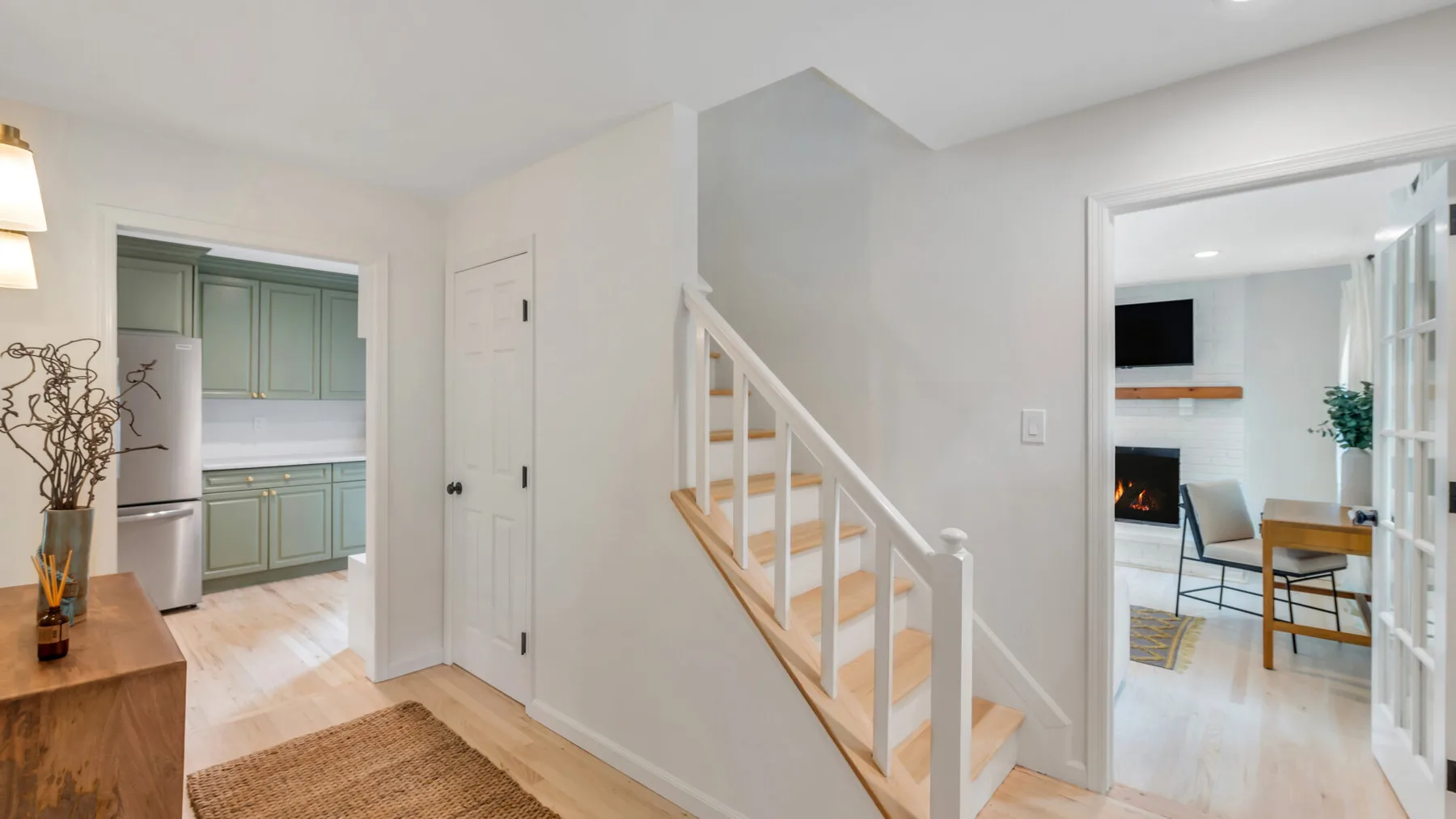 Un interior luminoso muestra una escalera entre la cocina y la sala de estar.