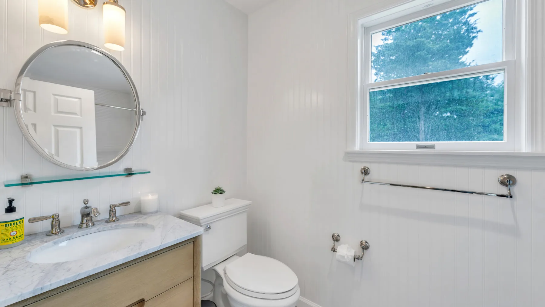 Un baño luminoso con lavabo, inodoro y ventana.