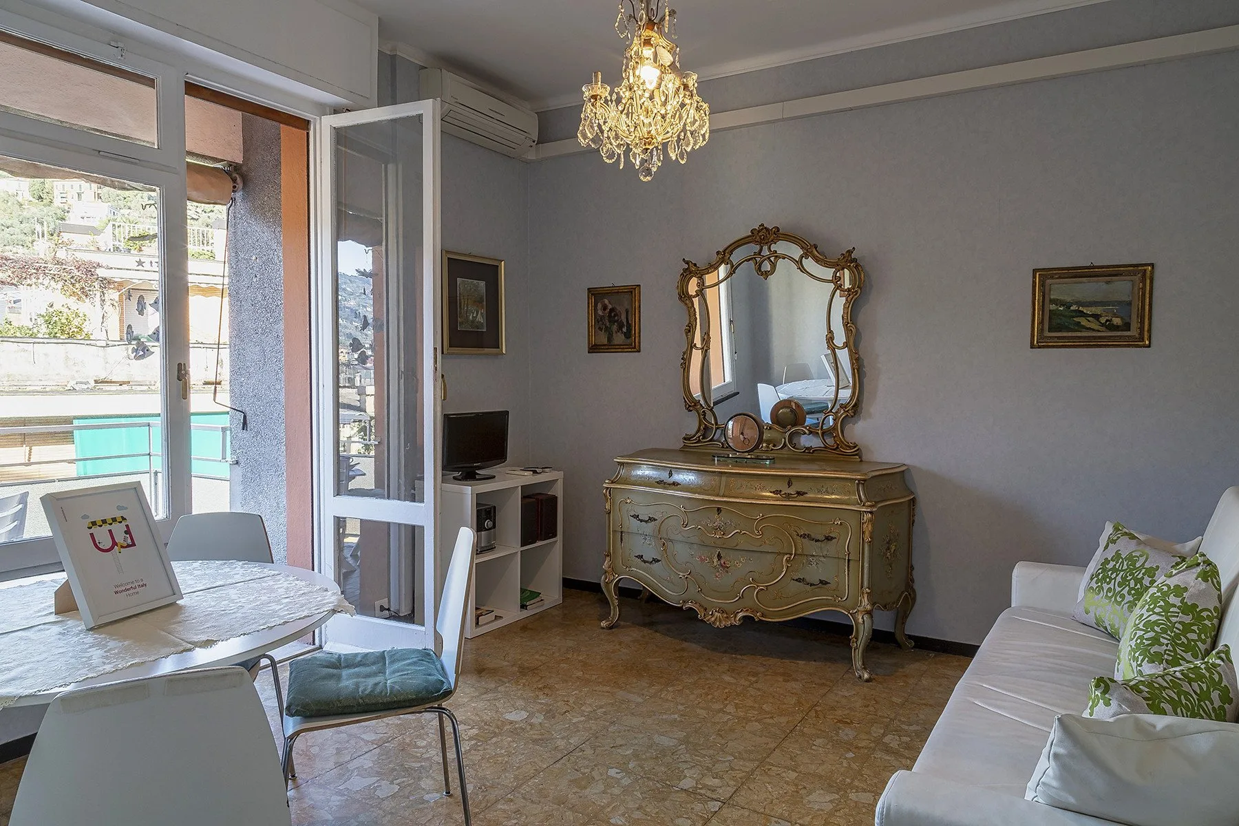 Una sala de estar con un espejo decorativo sobre una cómoda ornamentada y asientos.
