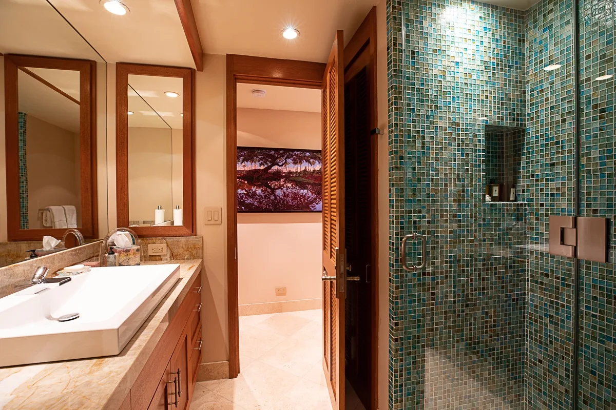 Un baño con lavabo y una ducha de azulejos.