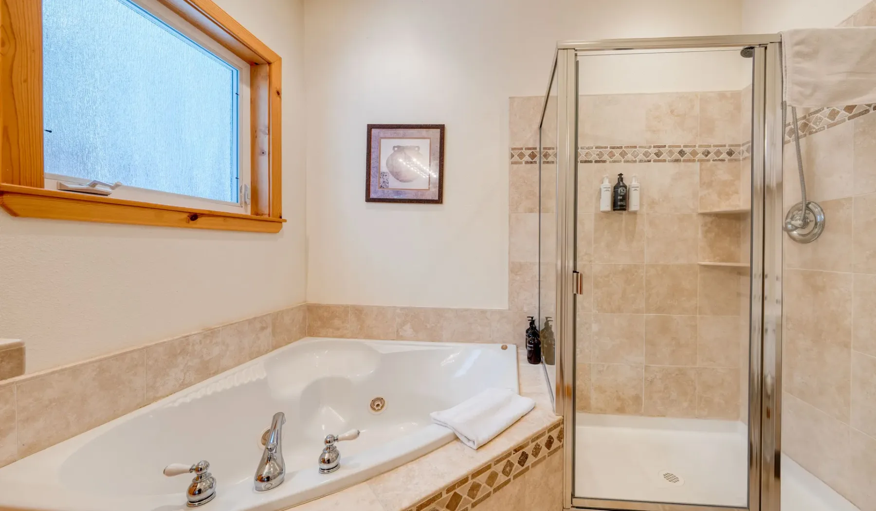 Un baño con bañera empotrada y ducha con mampara de vidrio.