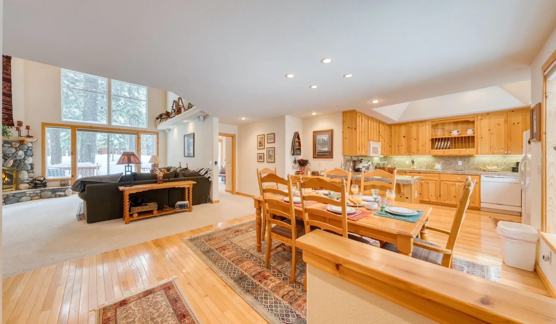 Un espacio diáfano de comedor y sala de estar con una mesa de madera y cocina.