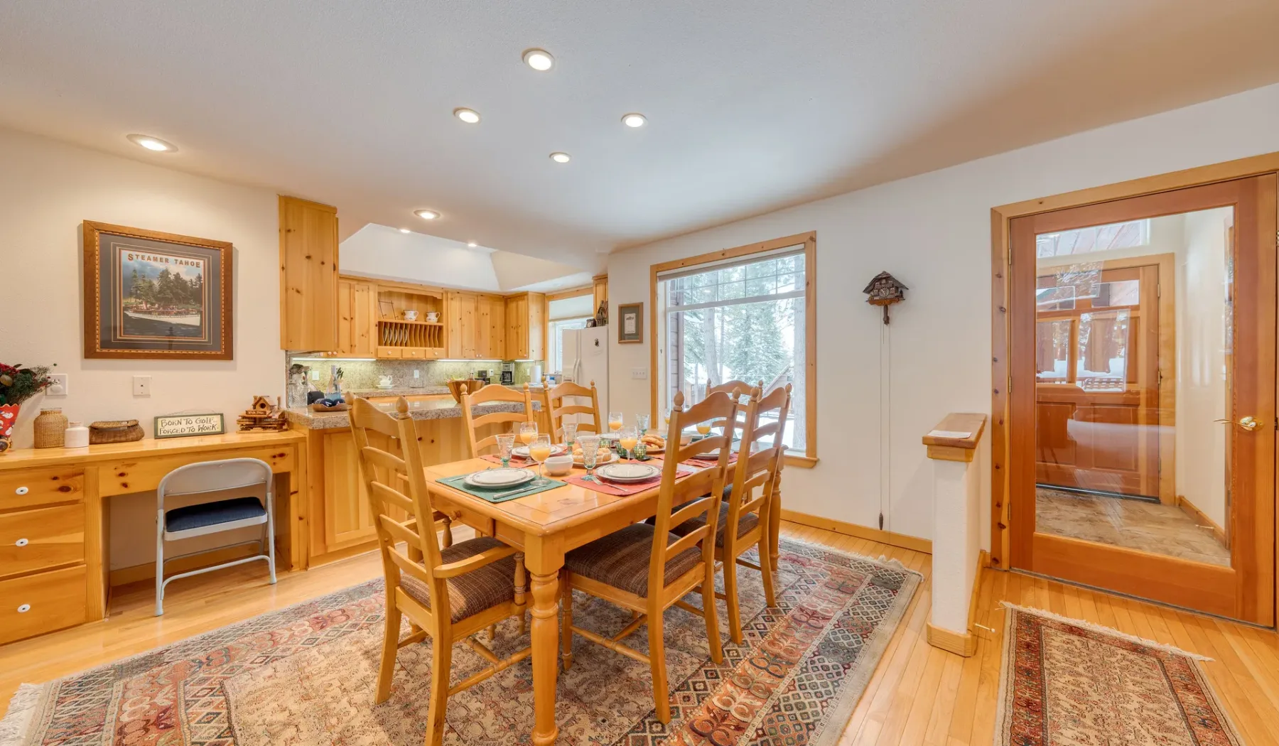Un cálido comedor con una mesa y sillas de madera junto a una cocina.