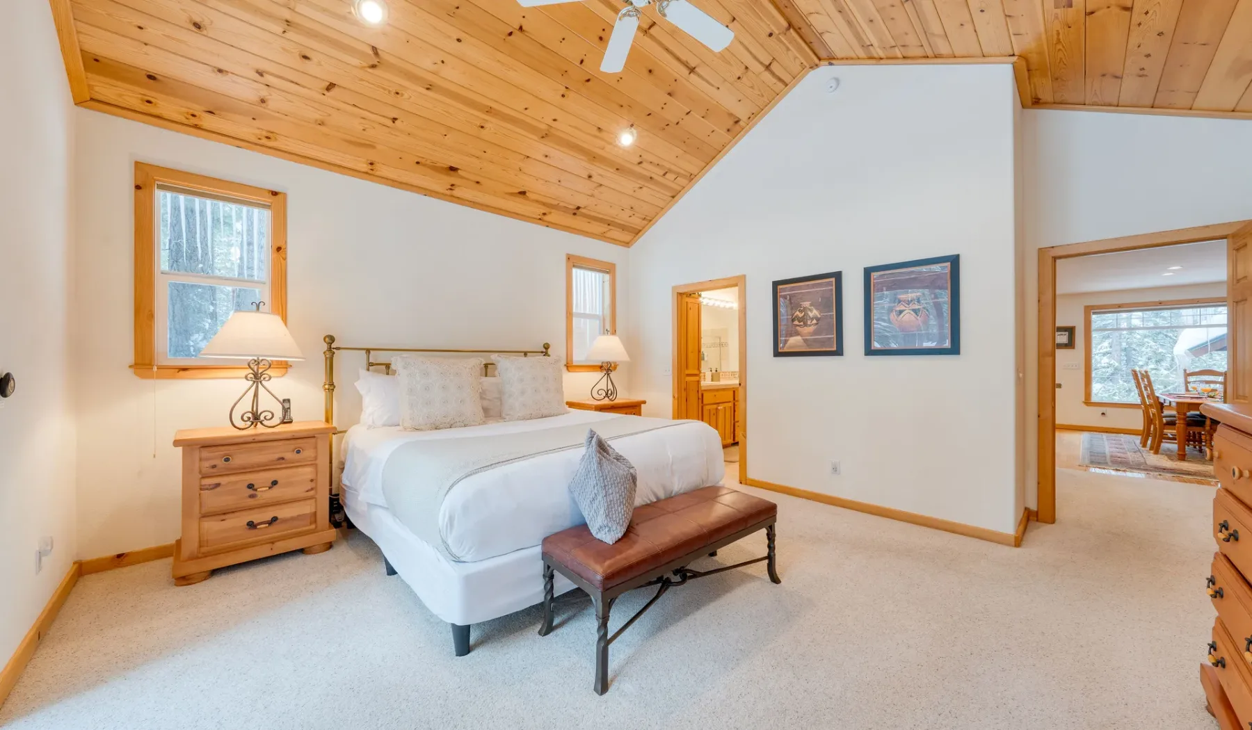 Un dormitorio con una cama bajo un techo inclinado revestido de madera.