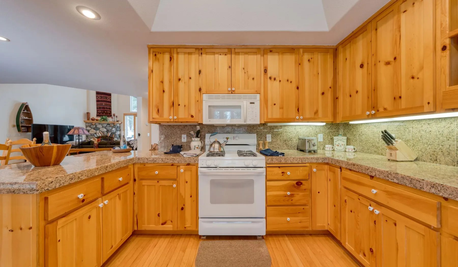Una cocina revestida de madera, con un horno central y encimeras a lo largo de las paredes.