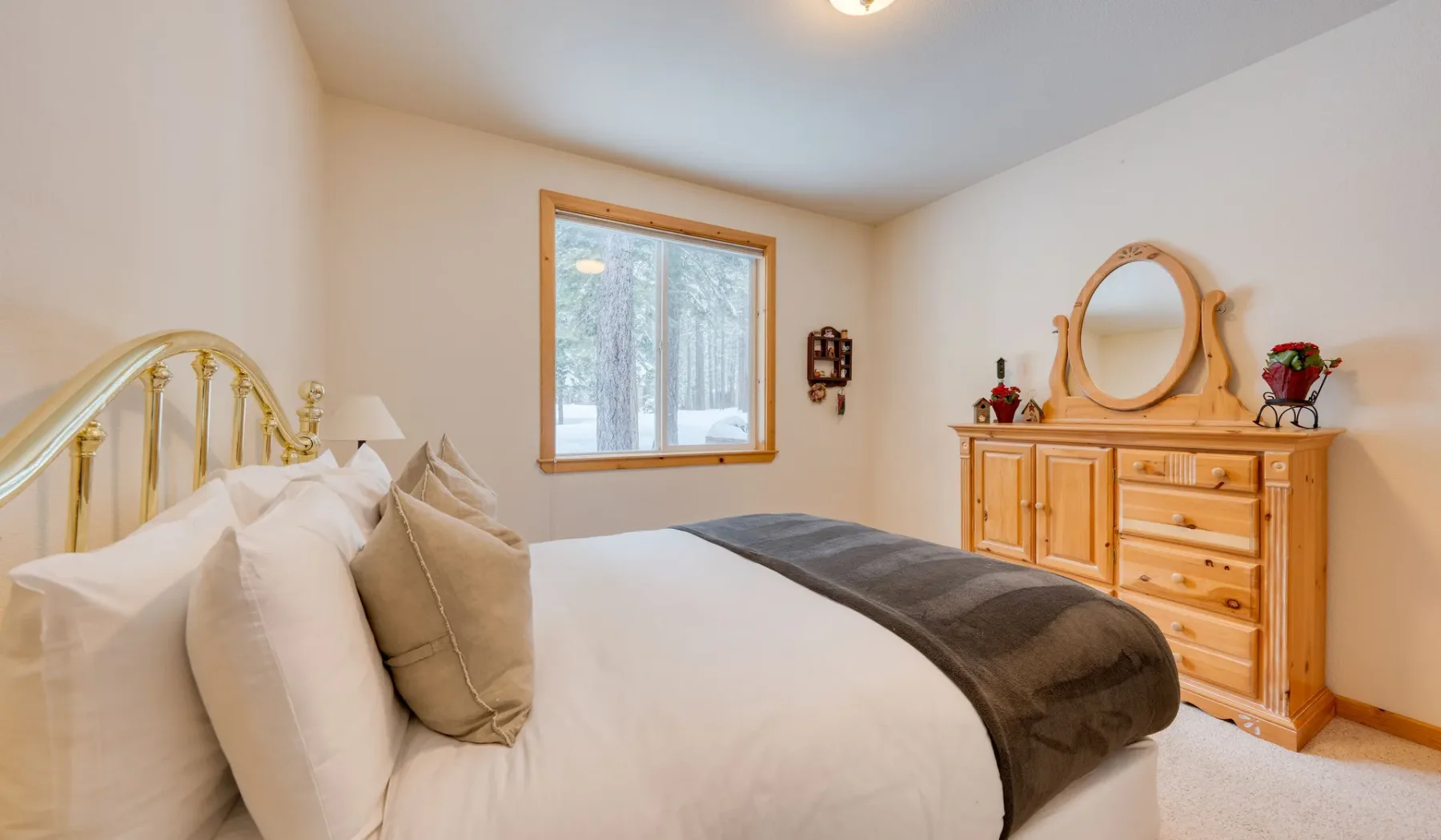 Un dormitorio con una cama, una ventana y una cómoda de madera.