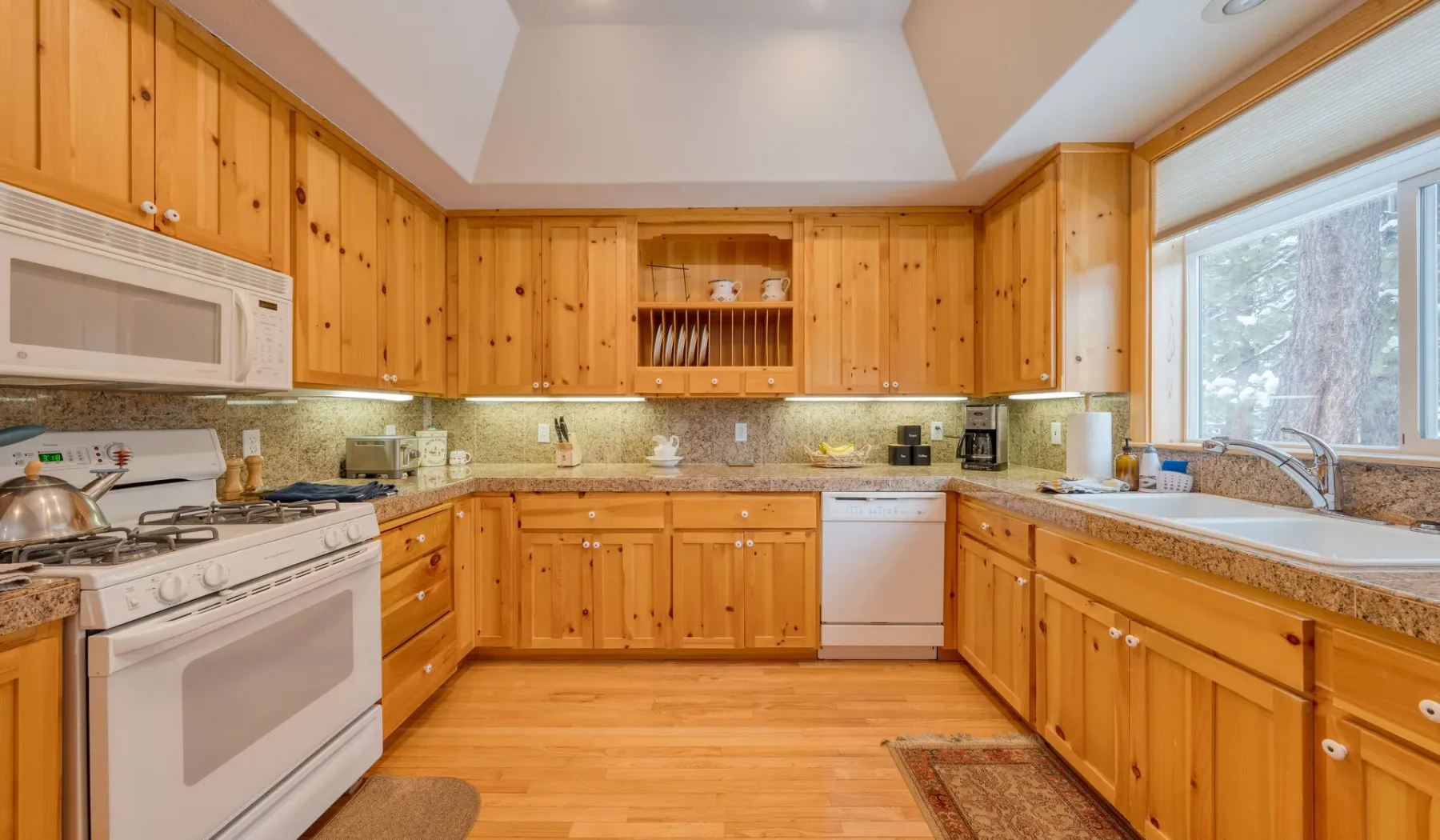 Una cocina luminosa con gabinetes de madera y una ventana grande.