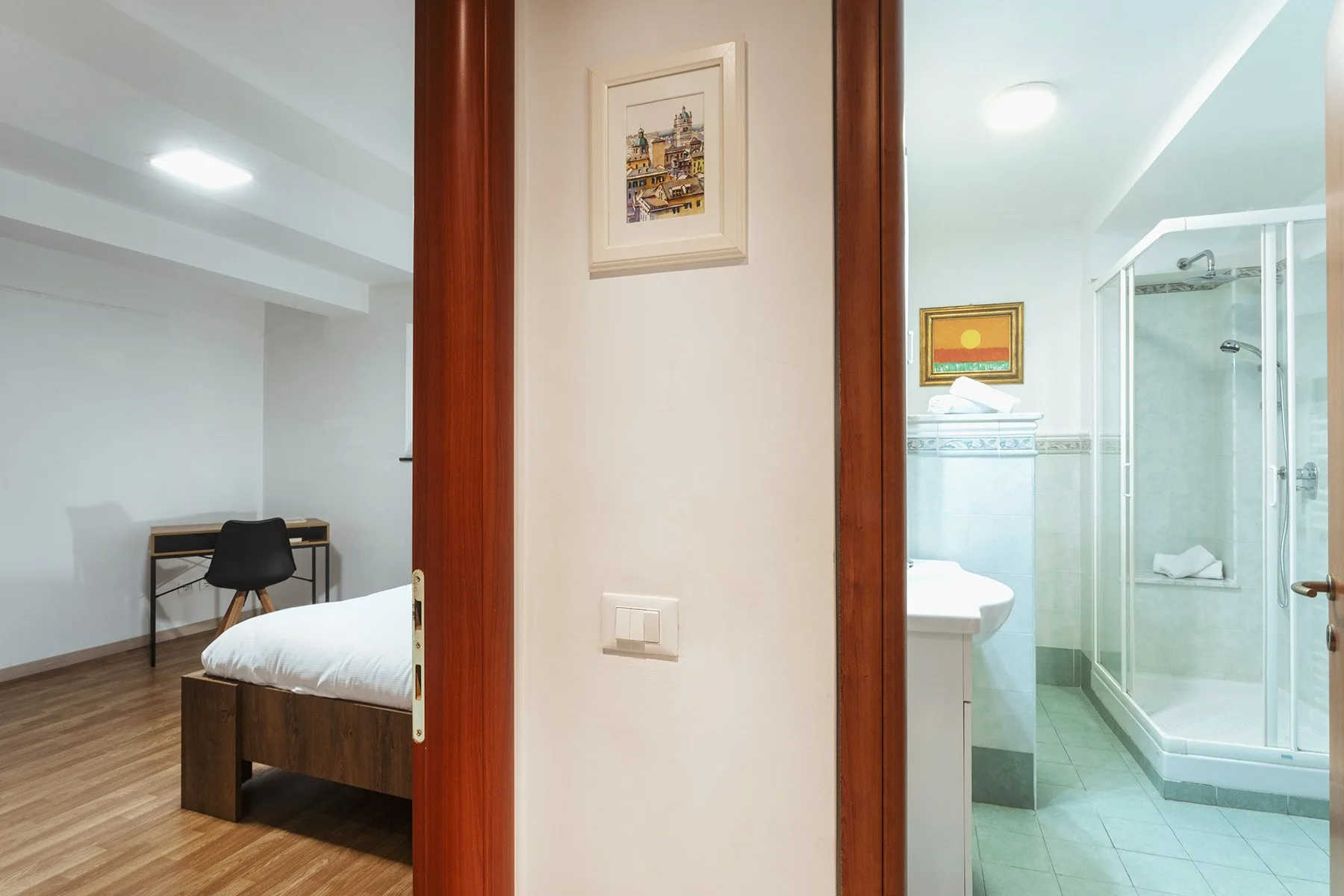 Se ven un dormitorio y un baño contiguo a través de las puertas abiertas.