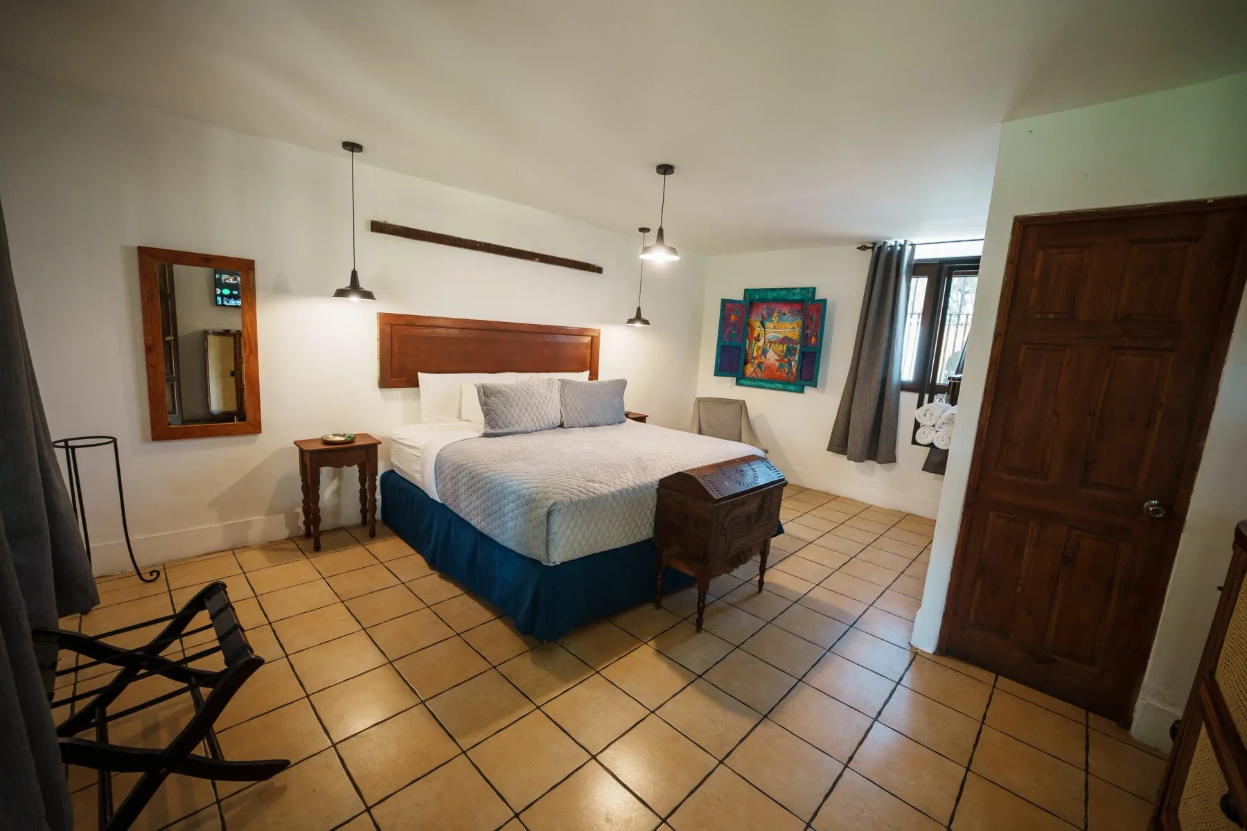 Habitación del hotel con una cama doble y detalles de madera de tonos cálidos.