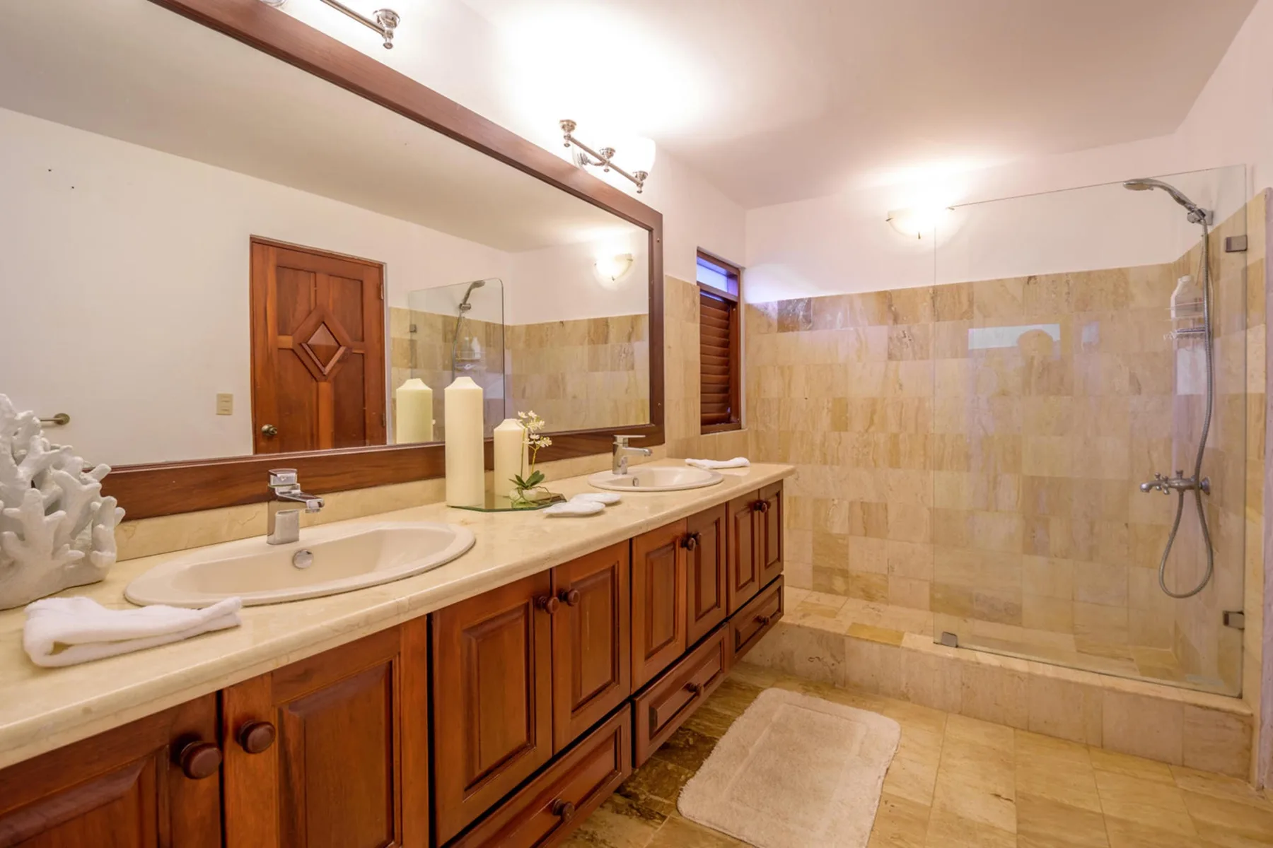 Un baño amplio con un tocador largo y una zona de ducha con azulejos.