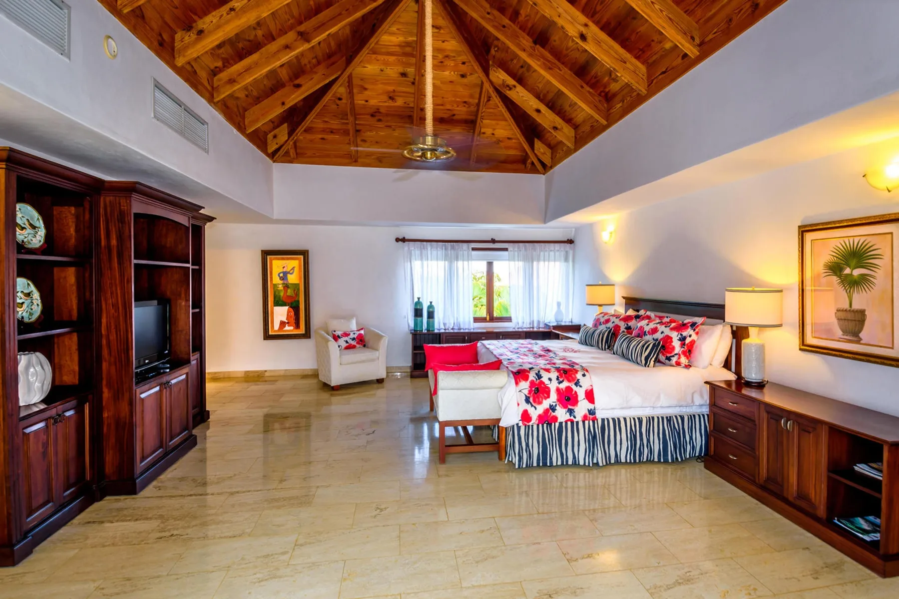 Un dormitorio con una cama grande, techo abovedado de madera y armarios empotrados.