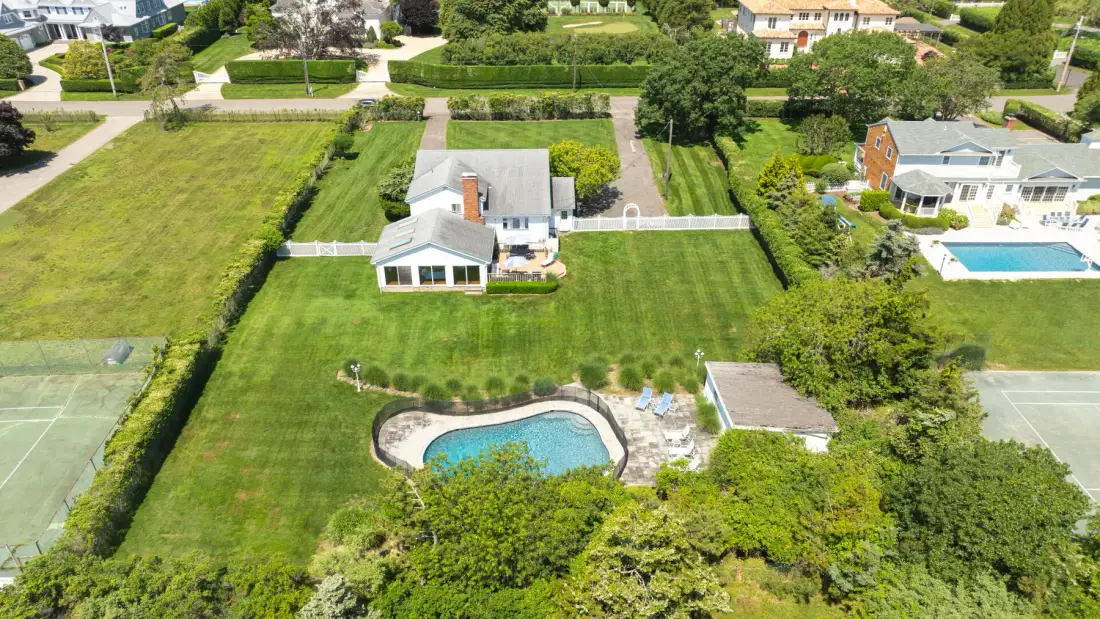 Aerial view of a house and landscaped yard with a swimming pool.