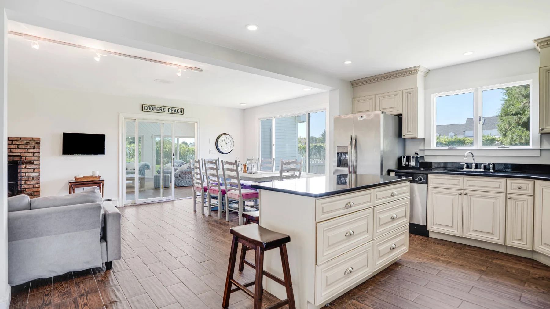 Una cocina y comedor de planta abierta con una isla central y ventanas grandes.