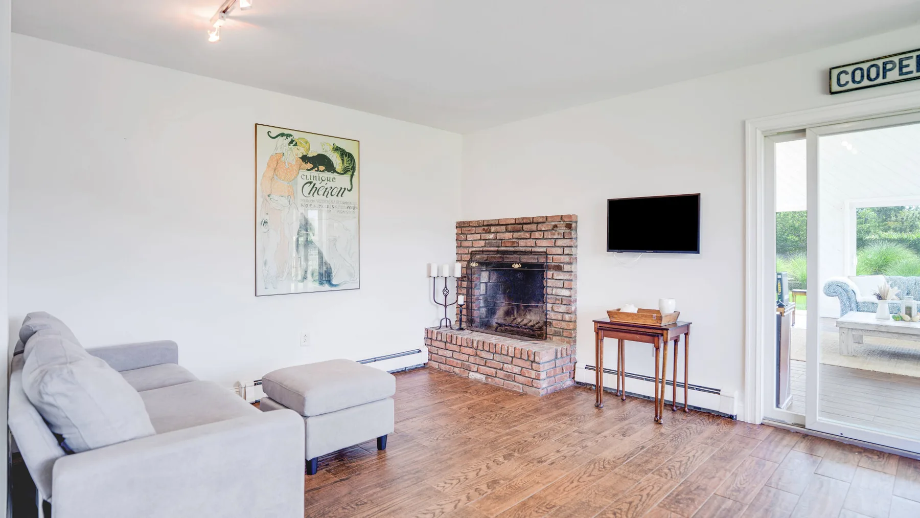 Una sala de estar con asientos, una chimenea de ladrillo y un televisor.