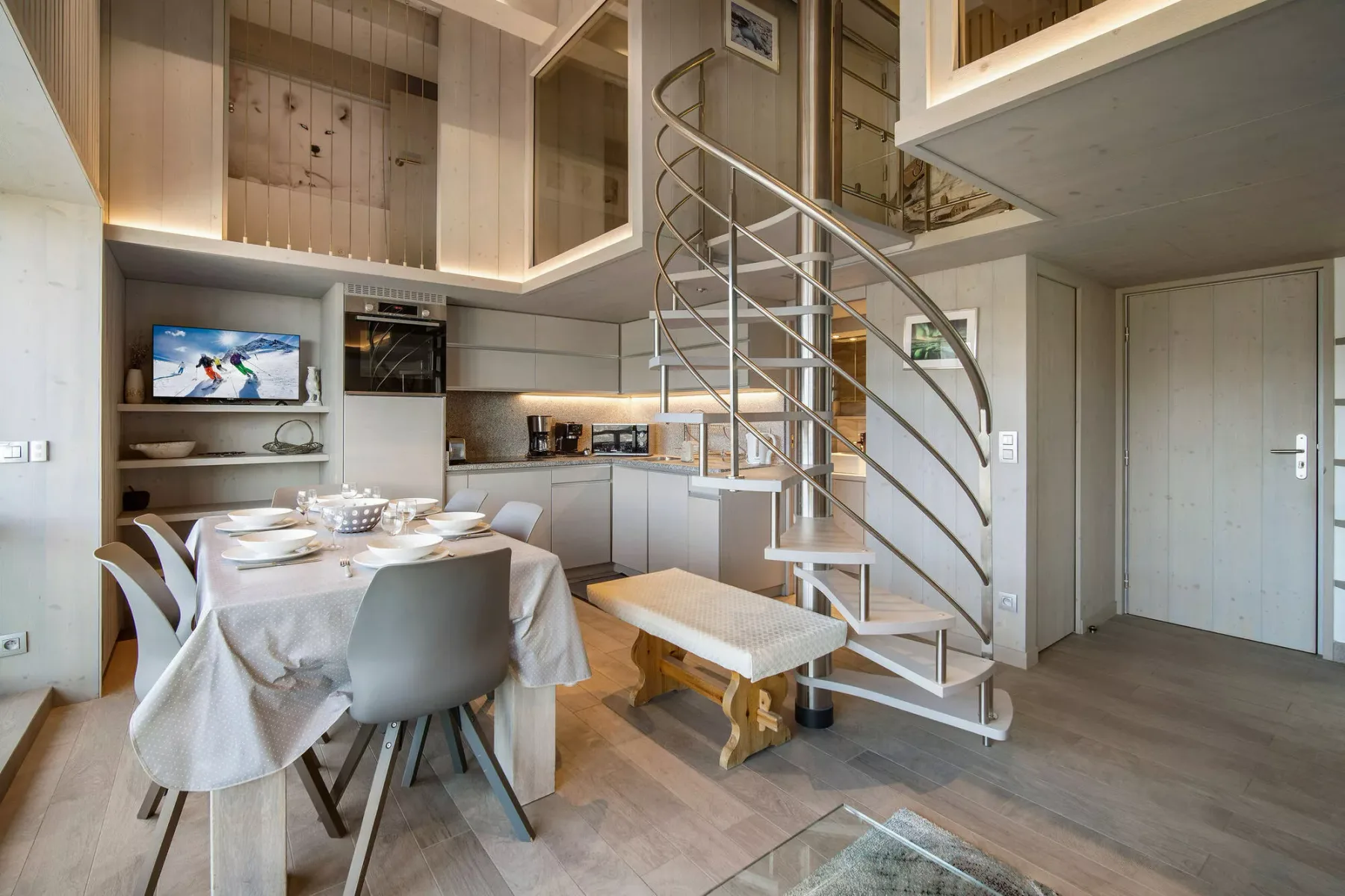 Comedor junto a una cocina, con una escalera de caracol.