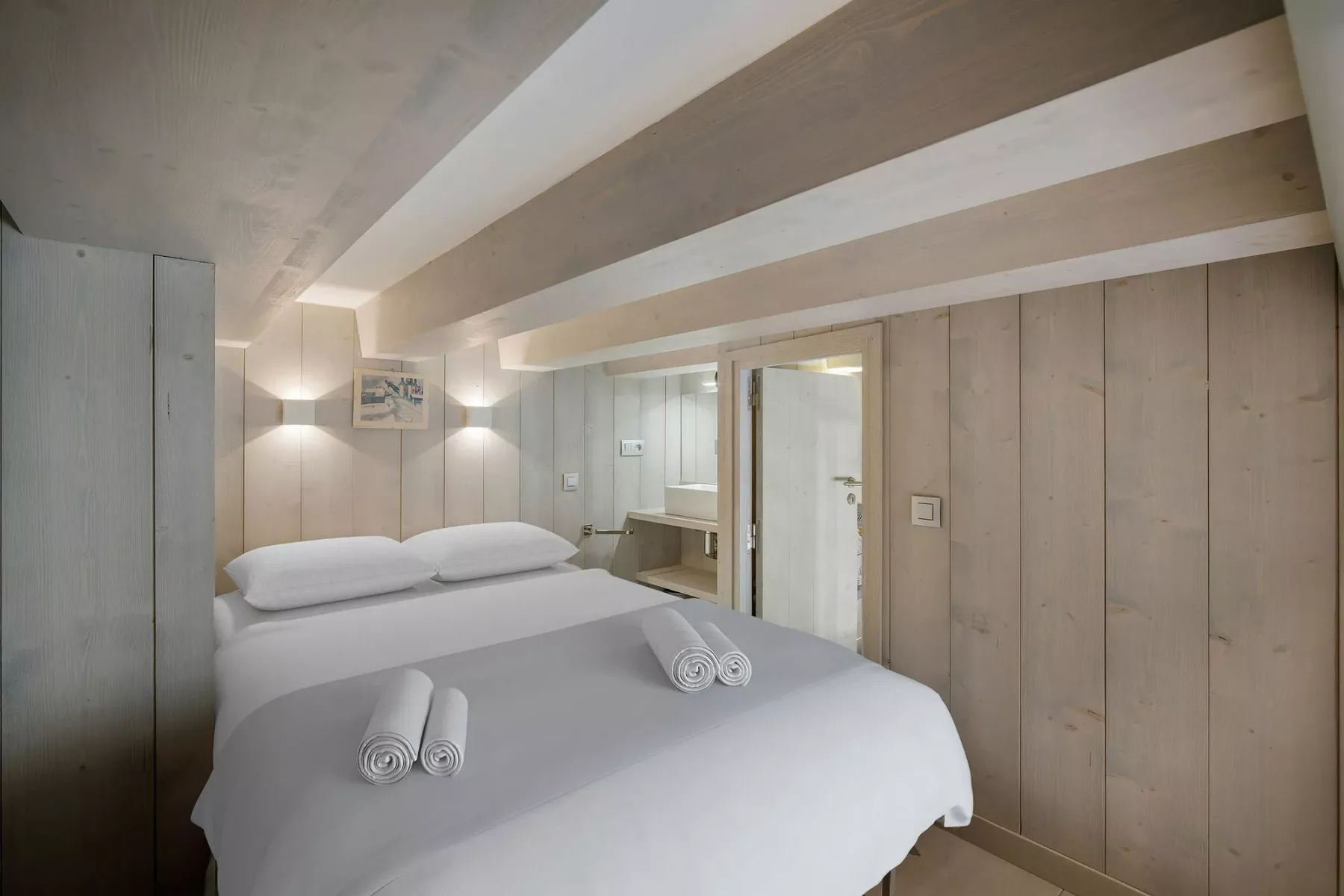 A bedroom with a double bed and a doorway leading to a bathroom.