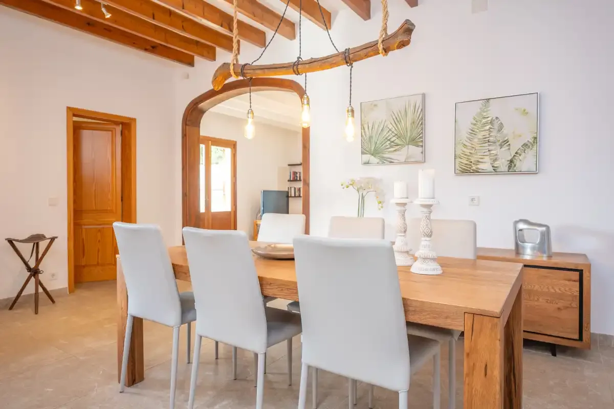 A dining room with a wooden table and light-colored seating.