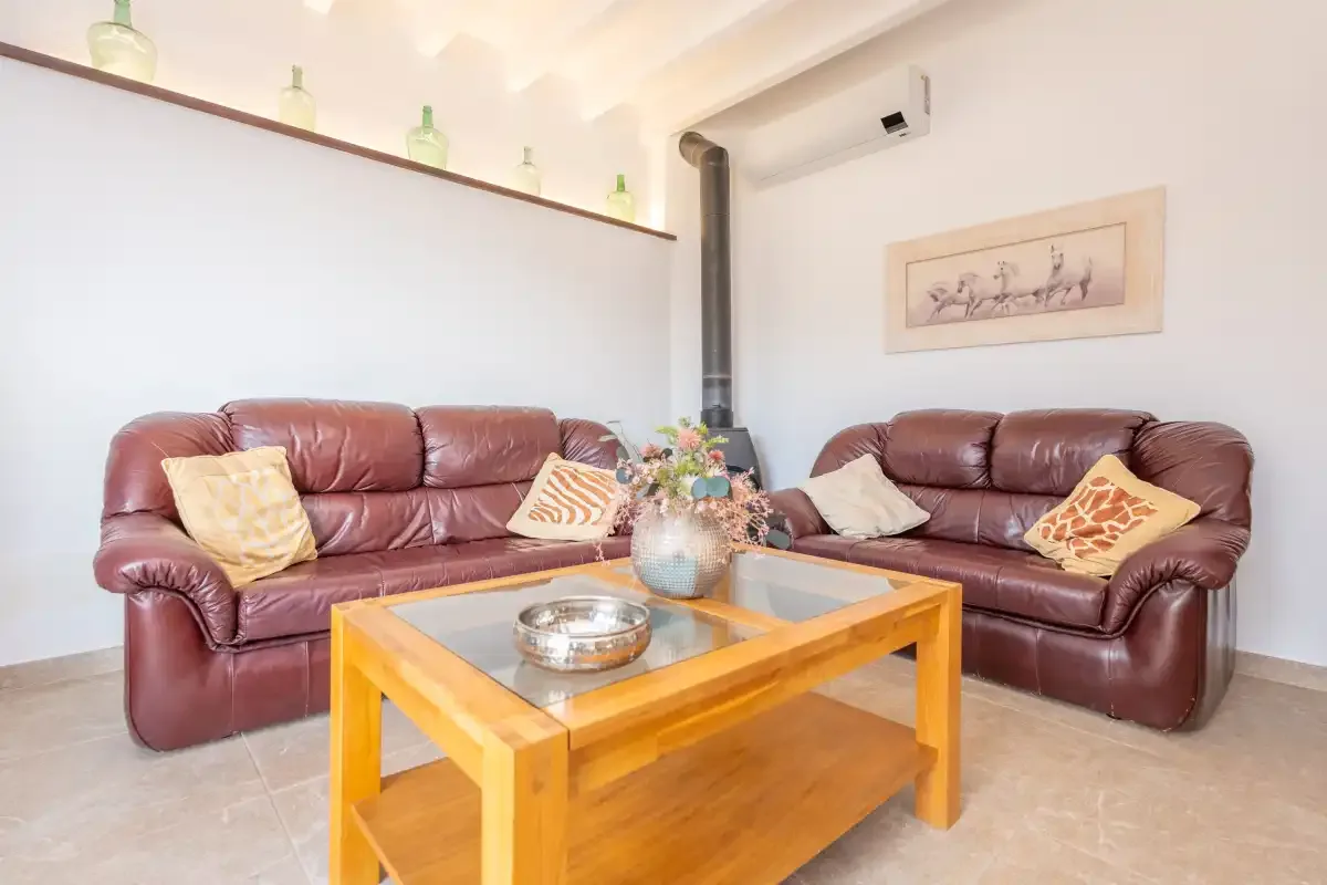 A living room with leather seating and a wooden coffee table.