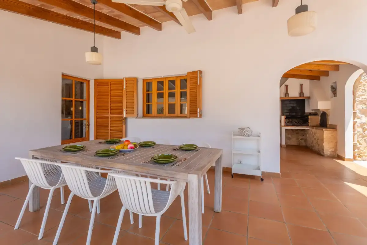 A dining area with a table and chairs beside an open kitchen.