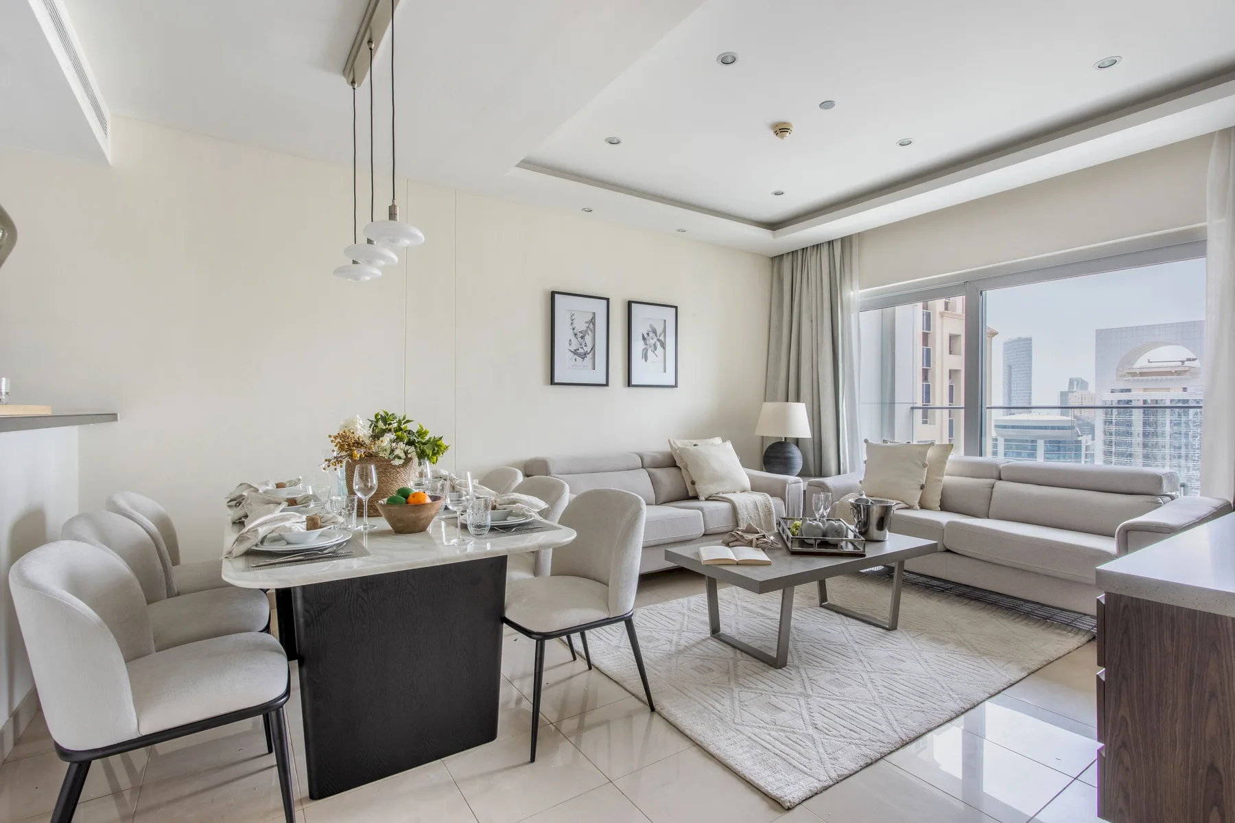 Una sala luminosa con mesa de comedor y asientos junto a grandes ventanas.