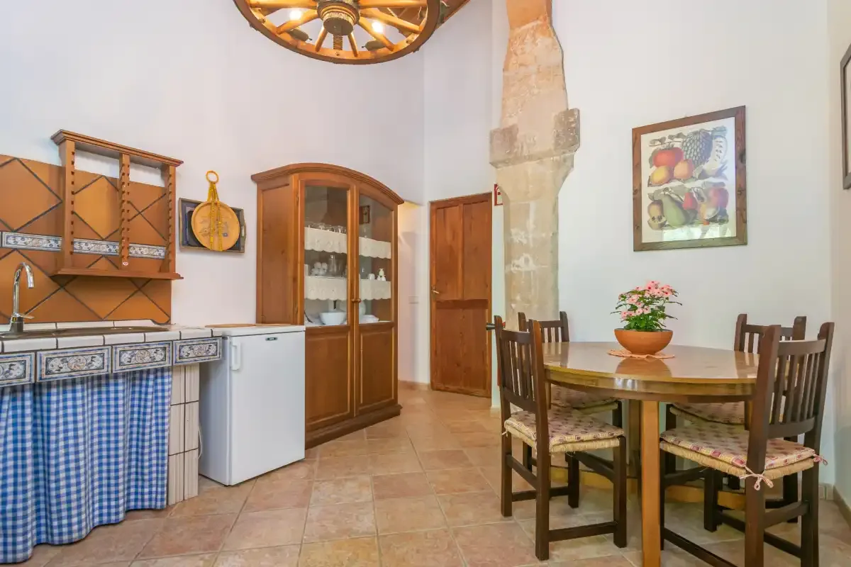 A rustic dining area with wooden seating, a table, and a tiled counter.