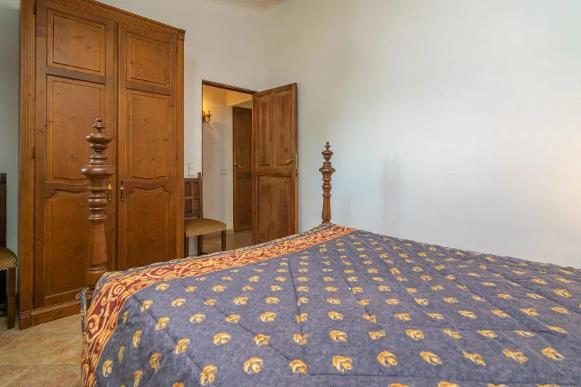 A bedroom with a patterned bedspread and wooden doors.