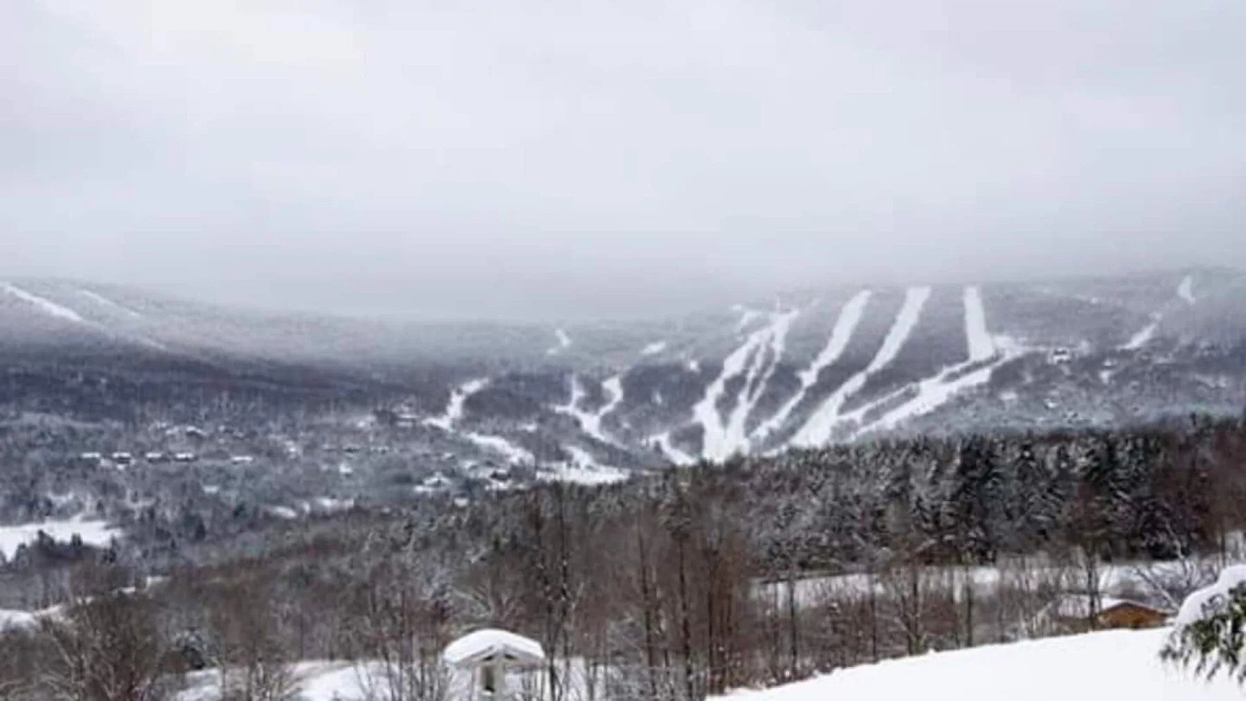 A snowy mountain landscape with ski trails winding across the slopes.