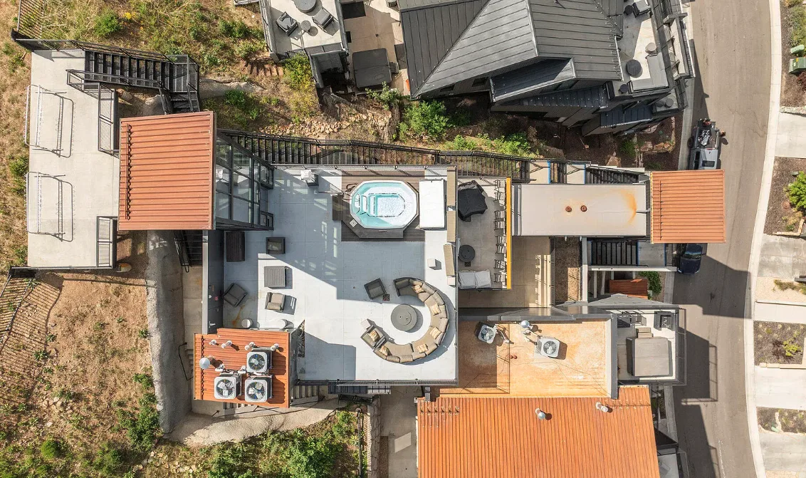 An aerial view of a rooftop terrace with seating and a small pool.