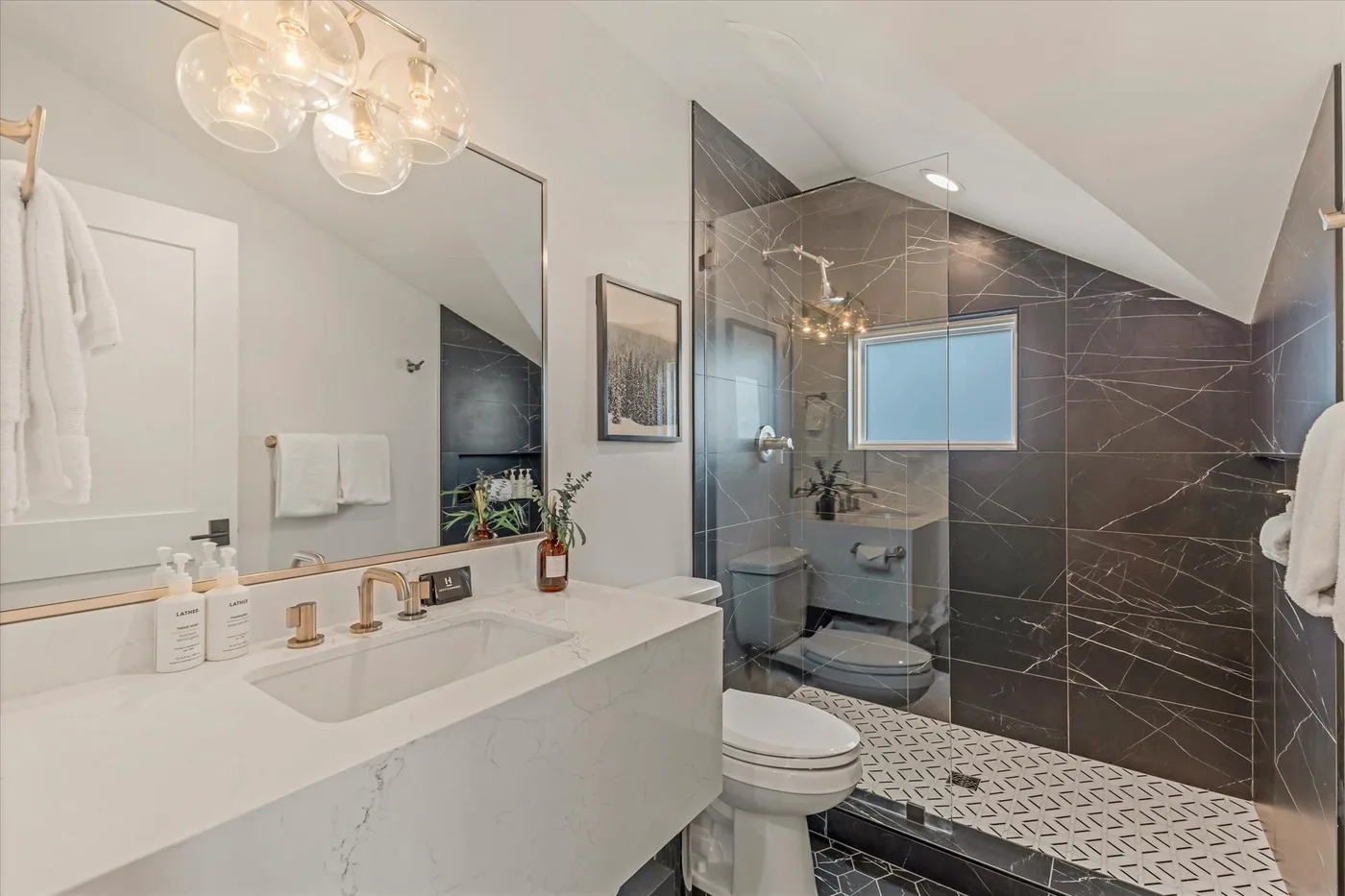 A modern bathroom with a long vanity, mirror, and glass shower.