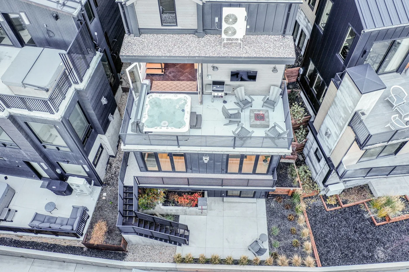 An elevated view of an outdoor terrace with seating and a hot tub.